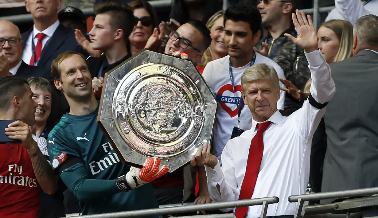 Pelatih Arsenal Arsene Wenger mnengangkat trofi Community Shield bersama Petr Cech saat merayakan kemenangannya dalam pertandingan FA Community Shield di Stadion Wembley di London, Inggris (6/8). (AFP Photo/Ian Kington)