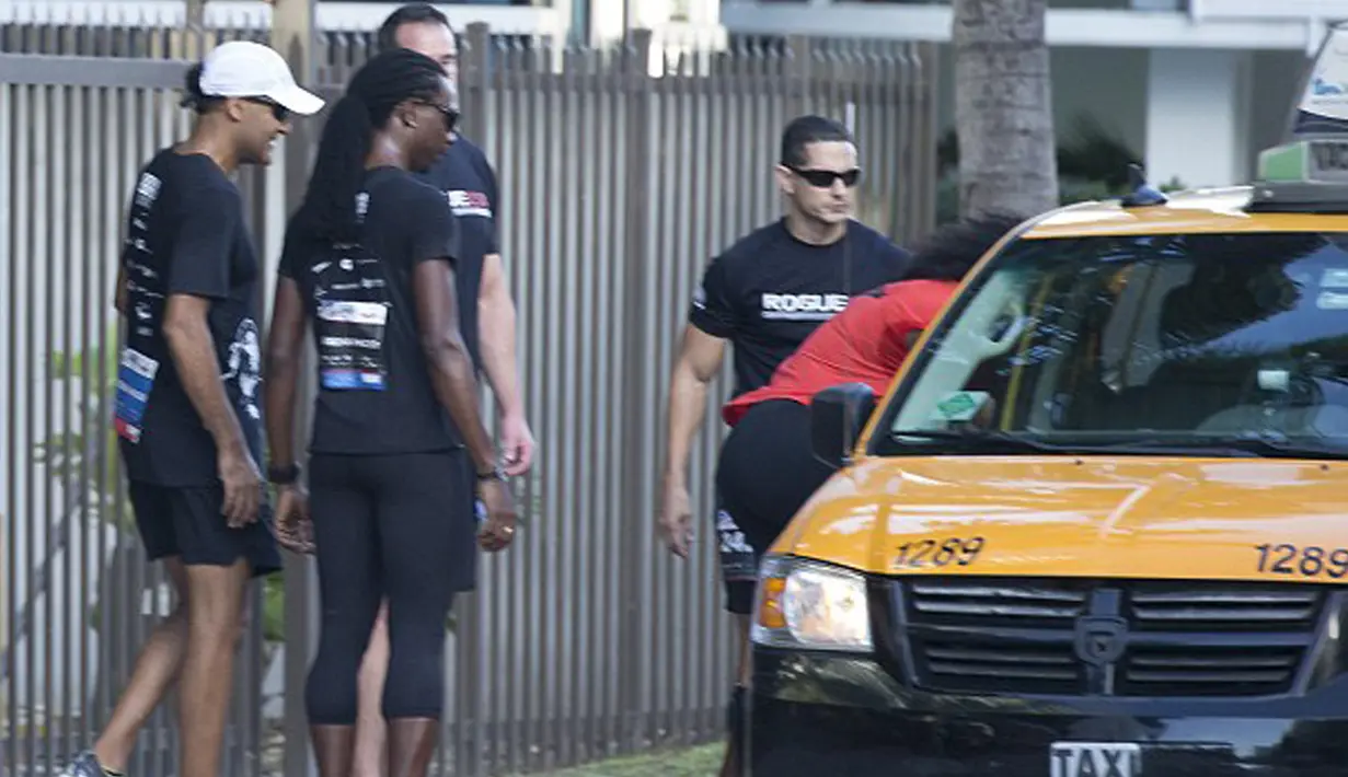 Serena Williams dibantu rekannya, terlihat memanggil sebuah taksi. Taksi yang dinaiki perempuan 34 tahun itu kemudian melaju menuju garis akhir dari perlombaan lari amal yang diselenggarakan di Miami Beach, Florida, Senin (14/12/2015). (dailymail.co.uk)
