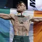 Conor McGregor membentangkan bendera Irlandia saat timbang badan jelang melawan Floyd Mayweather di Las Vegas (25/8/2017). McGregor akan bertarung 26 agustus 2017. (AP/John Locher)