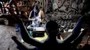 Seorang perajin mengerjakan wajah patung tanah liat dewi Hindu Durga di sebuah lokakarya menjelang festival Durga Puja di Vashi di Navi Mumbai (23/9/2021). Durga Puja  adalah festival tahunan di Asia Selatan untuk memuja dewi Durga dari agama Hindu. (AFP/Indranil Mukherjee)