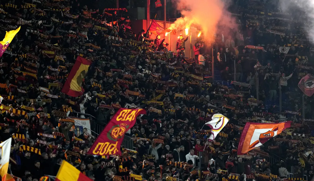 Sejumlah suporter AS Roma menyalakan suar saat mendukung timnya pada laga lanjutan Liga Italia 2023/2024 melawan Cagliari di Olympic Stadium, Roma, Italia, Selasa (06/02/2024) dini hari WIB. (AP Photo/Andrew Medichini)