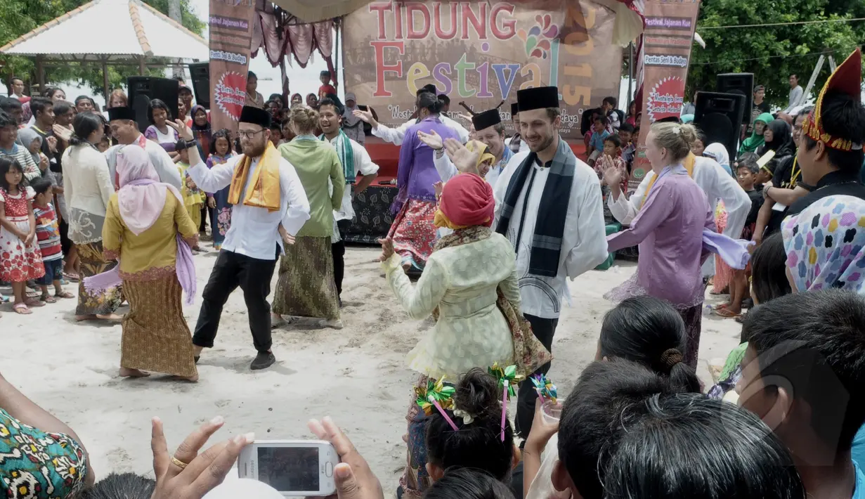 Peserta pertukaran pelajar Indonesia - Canada membawakan seni tradisional lenong dalam acara "Tidung Festival 2015" yang digelar di Pulau Tidung, Kepulauan Seribu, Jakarta, Sabtu (7/3/2015). (Liputan6.com/Andrian M Tunay)