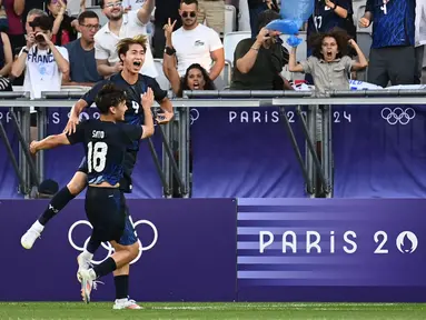 Penyerang Jepang #09 Shota Fujio (Atas) merayakan bersama Kein Sato setelah mencetak gol keempat timnya ke gawang Paraguay pada laga Grup D Olimpiade 2024 di Stade Matmut-Atlantique, Bordeaux, Kamis (25/7/2024) dini hari WIB. (Christophe ARCHAMBAULT / AFP)