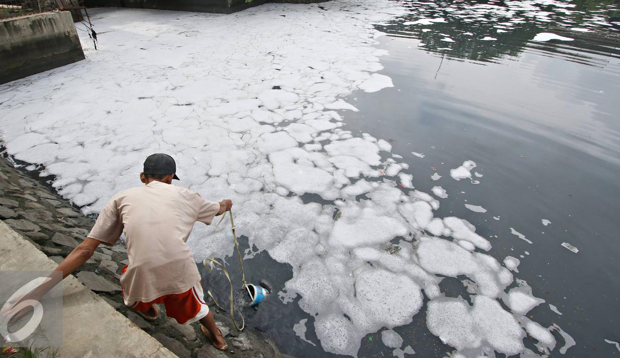 Warga mengambil air dari kali yan tertutup limbah busa, Jakarta, Selasa (16/2). Buruknya tata kelola air di Ibukota menjadi penyebab kondisi Kali Ancol selalu dipenuhi limbah busa, yang merupakan indikator pencemaran air. (Liputan6.com/Immanuel Antonius)