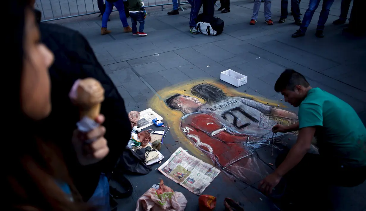 Seniman Chili melukis tindakan provokasi Gonzalo Jara terhadap pemain Uruguay, Edinson Cavani di trotoar jalan di Santiago, Chili (28/6/2015). Akibat aksinya Jara didenda 7.500 dollar Amerika Serikat atau sekitar Rp 100 juta. (REUTERS/Marcos Brindicci)