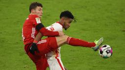 Bek Bayern Munich, Benjamin Pavard (kiri), berebut bola dengan gelandang RB Leipzig, Christopher Nkunku, dalam laga lanjutan Liga Jerman pekan ke-10 di Allianz Arena, Sabtu (5/12/2020). Bayern Munich bermain imbang 3-3 dengan RB Leipzig. (AFP/Alexander Hassenstein/Pool)