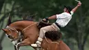 Seorang gaucho atau koboi menunggangi kuda liar saat kompetisi rodeo di San Antonio de Areco , Argentina, Minggu (8/11). Di acara ini, para gaucho atau koboi saling bersaing menunjukkan keahlian mereka menunggangi kuda liar. (AFP PHOTO / Eitan Abramovich)