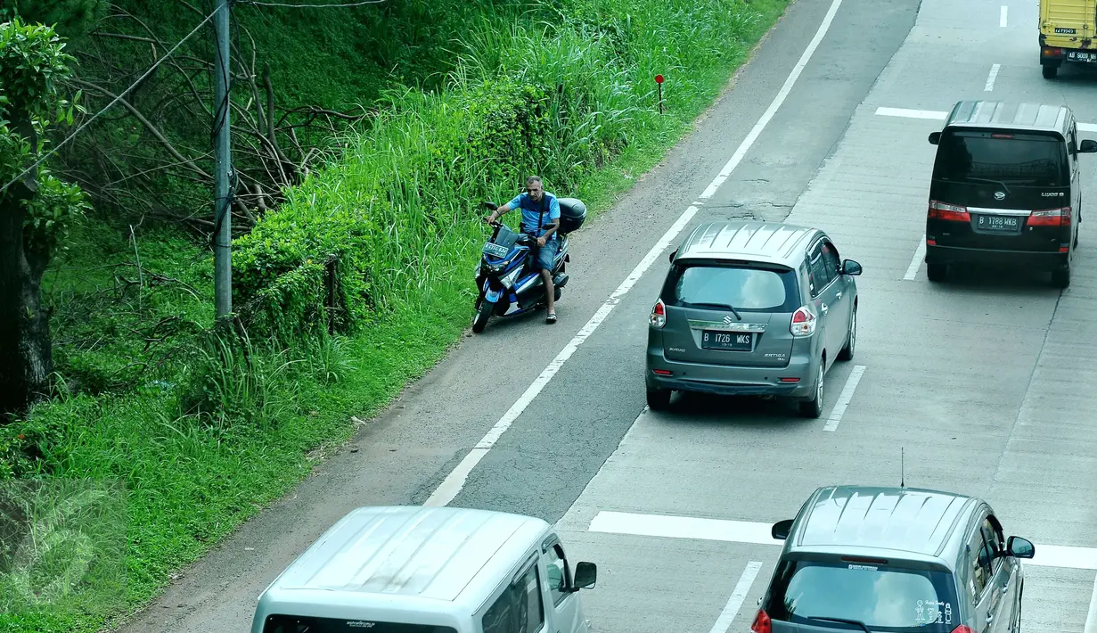 Seorang pengendara motor memasuki Tol Ulujami - Serpong, Tangerang Selatan, Jumat (14/4). Minimnya rambu peringatan dan penjagaan dari petugas, membuat pengendara motor tersebut terjebak masuk ke jalur menuju pintu Tol. (Liputan6.com/Helmi Afandi)