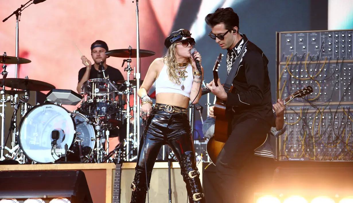 Miley Cyrus (kiri) tampil bersama musikus Mark Ronson pada hari terakhir Festival Glastonbury di Worthy Farm, Somerset, Inggris, Minggu (30/6/2019). Miley Cyrus tampil panas dengan gaya berapi-api saat menghibur ribuan penonton Festival Glastonbury. (Photo by Joel C Ryan/Invision/AP)