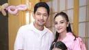 Ririn mengenakan gaun midi berwarna pink pastel yang terlihat anggun dan feminin. Gaun tersebut memiliki detail pita di bagian bahu, memberikan sentuhan manis sekaligus modern pada tampilannya. [@ririnekawati].