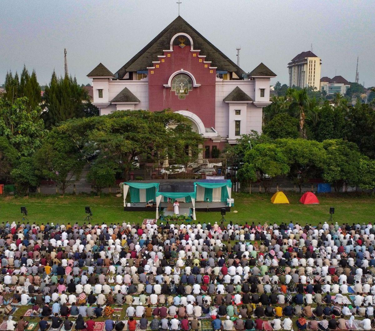 Umat Muslim di Depok melaksanakan Salat Iduladha 1445 Hijriah di Lapangan Lembaga Cornelis Chastelein yang terletak tepat di depan Gereja Bethel Indonesia. Foto: merdeka.com / Arie Basuki<br>