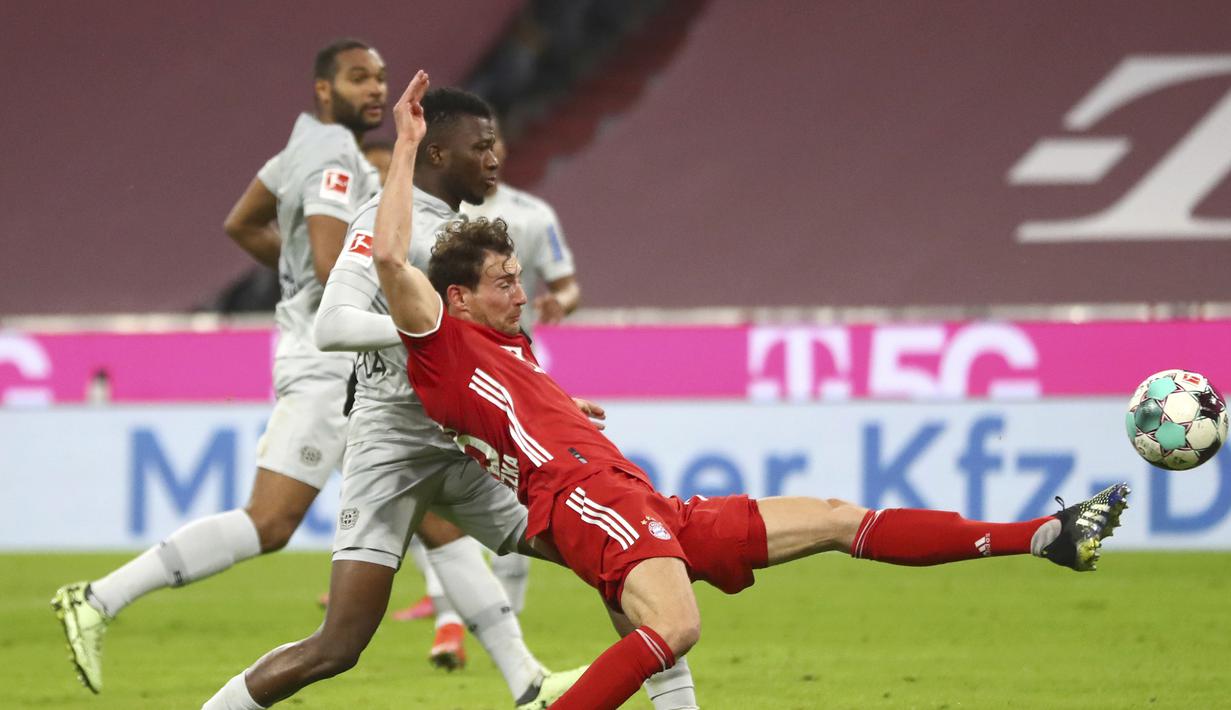 Gelandang Bayern Munich, Leon Goretzka (kanan) menguasai bola dibayangi bek Bayer Leverkusen, Edmond Tapsoba dalam laga lanjutan Liga Jerman 2020/2021 pekan ke-30 di Allianz Arena, Munich, Selasa (20/4/2021). Bayern Munich menang 2-0 atas Leverkusen. (AP/Matthias Schrader/Pool)