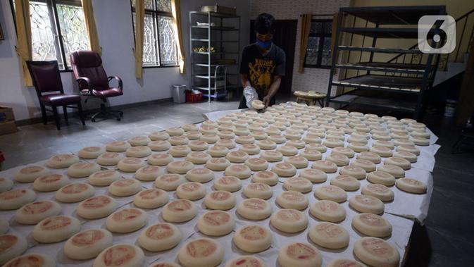 Pekerja menyelesaikan pembuatan kue bulan di Industri Rumahan Kue Bulan Putri Lauw, Pondok Sentul, Ciater, Tangerang Selatan, Selasa (10/11/2020). Pada masa pandemi sekarang, produksi kue tradisional khas Tionghoa tersebut menurun sesuai pesanan pembeli. (merdeka.com/Dwi Narwoko)