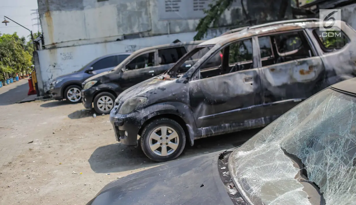 Kondisi mobil yang dibakar dan dirusak massa pasca bentrok pengunjuk rasa dan polisi di Polsek Tanah Abang, Jakarta, Selasa (1/10/2019). Mobil yang sedang terparkir tersebut diduga telah dibakar oleh para demonstran sekitar pukul 22.00 WIB. (Liputan6.com/Faizal Fanani)