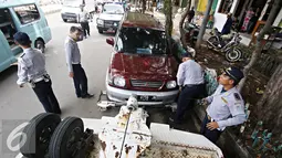 Petugas menderek kendaraan roda empat yang parkir sembarangan di kawasan Jatinegara, Jakarta Timur, Senin (28/12). Meski sudah ditertibkan, pengendara masih tak menghiraukan peraturan tersebut yang mengakibatkan kemacetan. (Liputan6.com/Immanuel Antonius)