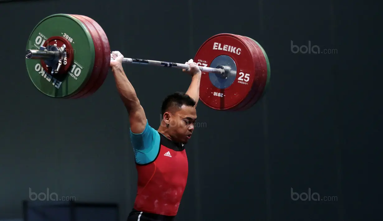 Aksi Eko Yuli Irawan menahan beban angkatan 135 kg snacth saat turun pada kelas 62 kg di Hall A Arena PRJ, Jakarta, Rabu (11/2/2018). Eko berhasil menyabet medali emas. (Bola.com/Nicklas Hanoatubun)