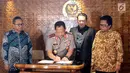 Kapolri Jendral Pol Tito Karnavian (kedua kiri) menandatangi kerjasama antara DPR dan Kepolisian RI di Kompleks Parlemen, Senayan, Jakarta, Rabu (14/2). (Liputan6.com/JohanTallo)