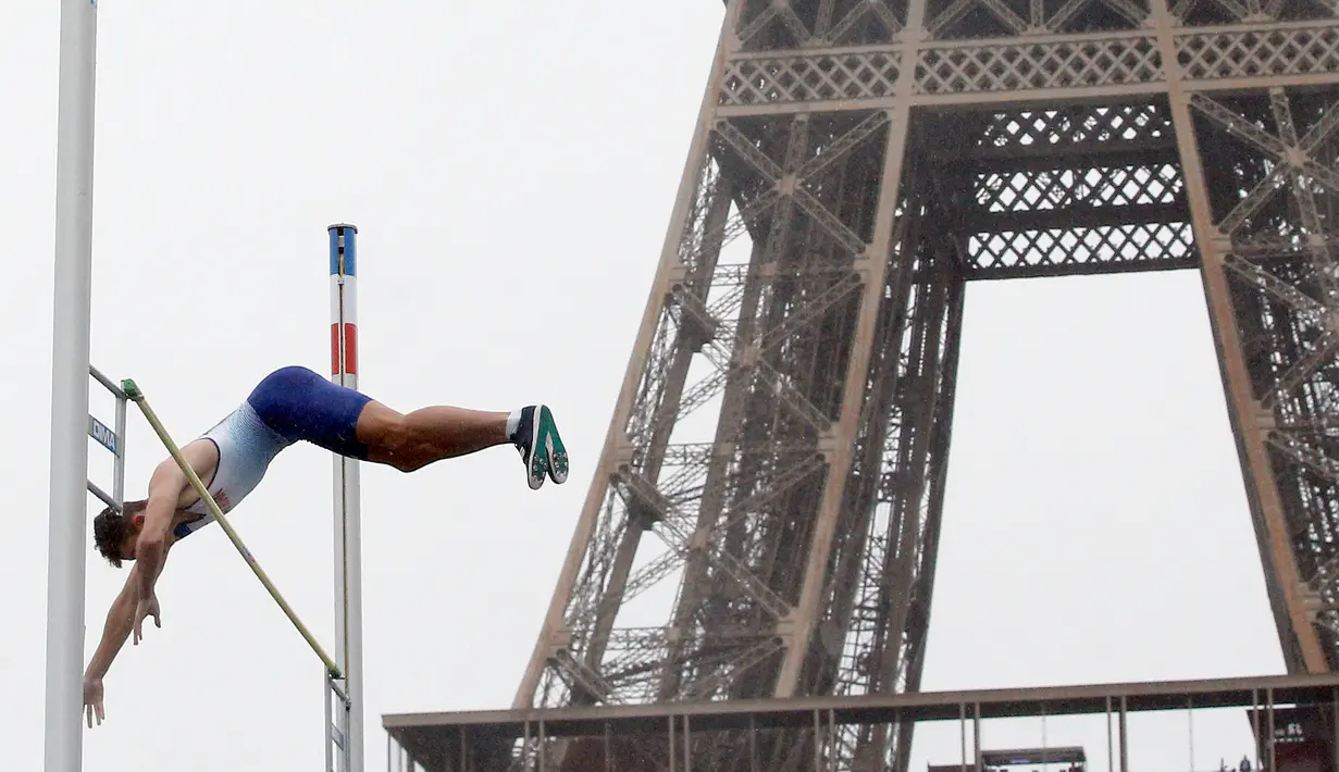 Atlet asal Inggris Joel Leon Benitez lakukan lompat gajah di depan Menara Eiffel, taman Champs de Mars, Paris, Rabu (13/9). Warga kota Paris sambut Olimpiade musim panas 2024 dengan mengadakan berbagai jenis kompetisi olahraga. (AP Photo/Thibault Camus)