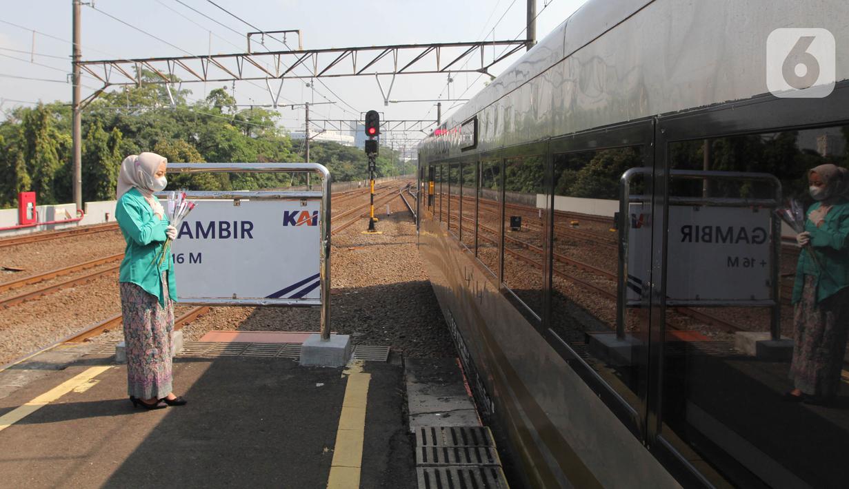 Petugas PT KAI Daop 1 Jakarta berkebaya memberikan gestur hormat saat rangkaian kereta berangkat dari Stasiun Gambir, Rabu (21/4/2021). Petugas perempuan itu mengenakan kebaya dan membagikan bunga kepada penumpang guna memeriahkan Hari Kartini yang jatuh pada hari ini. (Liputan6.com/Herman Zakharia)