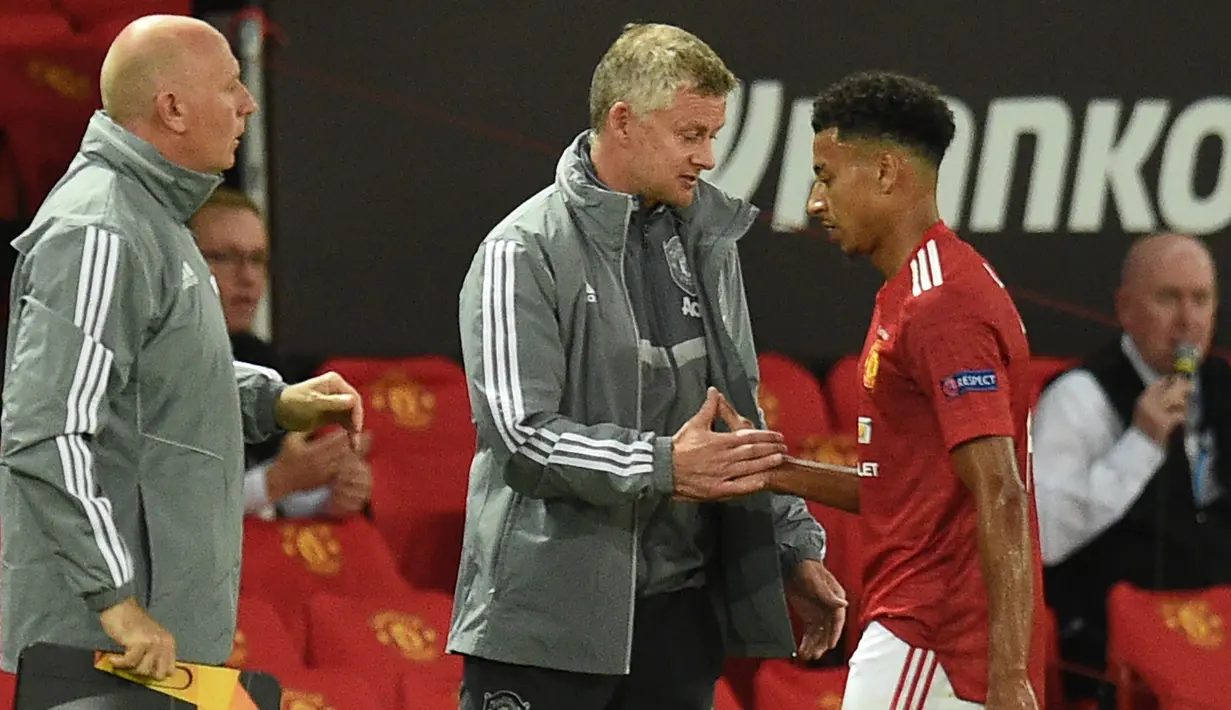Pelatih Manchester United, Ole Gunnar Solskjaer, berbincang dengan Jesse Lingard pada laga leg kedua 16 besar Liga Europa 2019/2020 di Old Trafford, Kamis (6/8/2020) dini hari WIB. Manchester United menang agregat 7-1 atas LASK. (AFP/Oli Scarff)