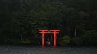 Torii (gerbang merah) dari kuil Hakone-Jinja terlihat di Danau Ashi di prefektur Kanagawa, Jepang (11/9/2019). Nama Danau Ashi atau yang dikenal juga dengan Danau Ashinoko ini dalam bahasa Jepang memiliki arti lautan alang-alang. (AFP Photo/Charly Triballeau)