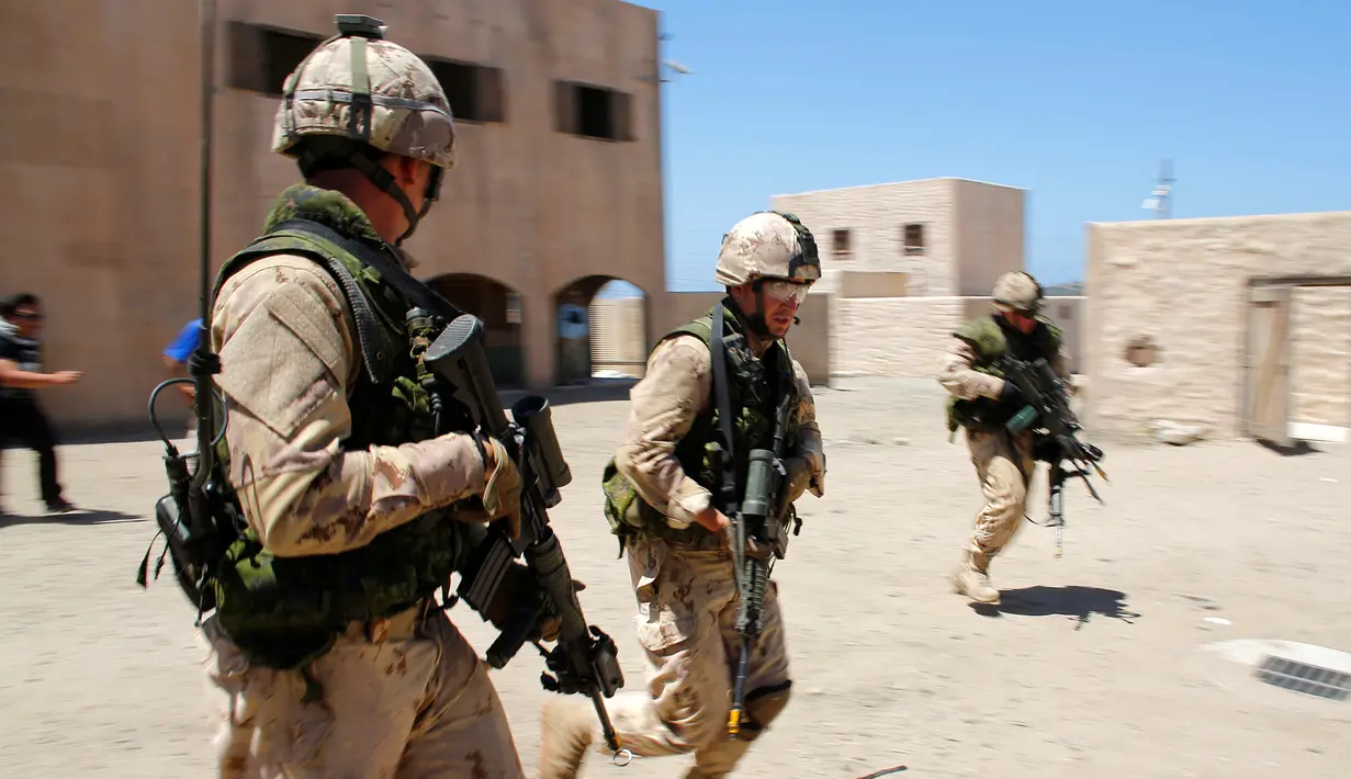 Tentara Kanada dari Resimen Kerajaan 22 berpatroli selama operasi ekstraksi non-agresif di sebuah desa dalam simulasi latihan Rim Pasifik (RIMPAC) 2016 di Camp Pendleton, California, Amerika Serikat, (11/7). (REUTERS/Mike Blake)