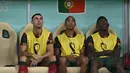 Cristiano Ronaldo (kiri) duduk di bangku cadangan bersama Joao Mario (tengah) dan Rafael Leao (kanan) selama pertandingan sepak bola babak 16 besar Piala Dunia 2022 antara Portugal dan Swiss di Stadion Lusail, Lusail, Qatar, Selasa (6/12/2022). Keputusan mencadangkan Ronaldo diambil oleh sang pelatih, Fernando Santos. (Paul ELLIS / AFP)