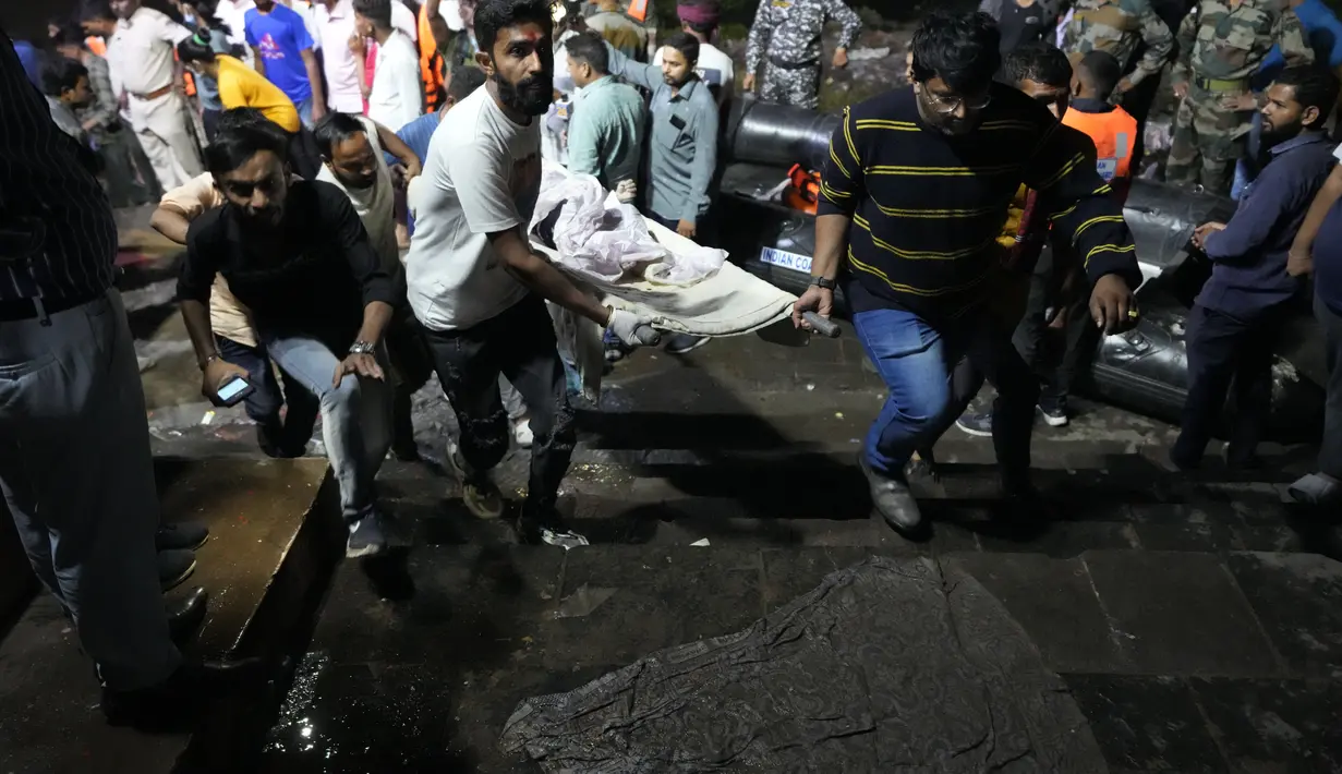 Relawan dan petugas kesehatan membawa korban setelah jembatan kabel di seberang sungai Machchu runtuh di kota Morbi, negara bagian Gujarat, India, Senin, 31 Oktober 2022. Puluhan orang tewas dan banyak yang dikhawatirkan terluka dalam kecelakaan itu. (AP/Ajit Solanki)
