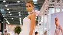 Seorang model yang mengenakan masker memperagakan gaun pengantin di pameran dagang European Bridal Week di Essen, Jerman, pada 5 Juli 2020. European Bridal Week diselenggarakan dengan menerapkan langkah pengendalian dan pencegahan COVID-19 yang ketat. (Xinhua/Tang Ying)