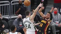 Guard Atlanta Hawks Trae Young melewati pemain Milwaukee Bucks Pat Connaughton pada paruh pertama game kedua final wilayah Timur NBA di Milwaukee, Sabtu, 26 Juni 2021. (Curtis Compton/Atlanta Journal-Constitution via AP)