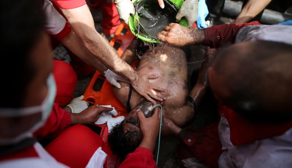 Petugas medis memberikan bantuan pernapasan kepada penambang batu bara yang berhasil dikeluarkan akibat ledakan yang terjadi di tambang di Azadshahr, Iran (3/5). (Mostafa Hassanzadeh/Tasnim News/AFP)