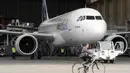 Salah satu pekerja hanggar di Saint-Martin-du-Touch, Toulouse, Perancis, melintas di depan pesawat Airbus A320neo yang akan menjalani uji jarak menengah, (1/7/2014). (AFP PHOTO/ERIC Cabanis)