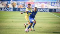 Striker Arema FC, Dalberto mempertahankan bola dari kejaran gelandang Persib Bandung, Thom Haye dalam laga pekan keenam BRI Super League 2025/2026 di Stadion Kanjuruhan, Kabupaten Malang, Senin (22/9/2025). (Bola.com/Iwan Setiawan).