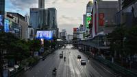 Kendaraan berjalan di persimpangan Ratchaprasong pada hari pertama penguncian COVID-19 yang lebih ketat di Bangkok, Senin (12/7/2021).  Thailand menerapkan lockdown untuk menekan laju penyebaran virus corona pada Senin, 12 Juli 2021 di Bangkok dan provinsi sekitarnya. (Lillian SUWANRUMPHA/AFP)