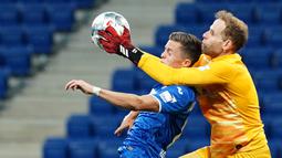 Kiper RB Leipzig, Peter Gulacsi, berebut bola dengan gelandang Hoffenheim, Christoph Baumgartner, pada laga lanjutan Bundesliga peka ke-30 di Rhein-Neckar Arena, Sabtu (13/6/2020) dini hari WIB. Leipzig menang 2-0 atas Hoffenheim. (AFP/Uwe Anspach/Pool)