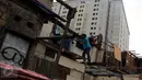 Seorang warga melakukan pembongkaran bangunannya sendiri di pinggir rel kereta api di kawasan Kelurahan Rawajati, Pancoran, Jakarta, Rabu (10/6/2015). Bangunan tersebut berdiri di atas tanah milik PT KAI. (Liputan6.com/Helmi Afandi)