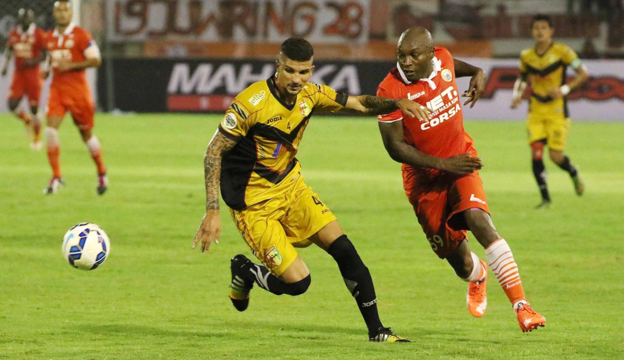 Pemain Mitra Kukar Asal Brasil, Artur (kiri) saat berebut bola dari Pemain Persija Jakarta , Pacho pada Piala Jenderal Sudirman di Stadion Manahan, Solo, Sabtu (12/12/2015). (Bola.com/Nicklas Hanoatubun)