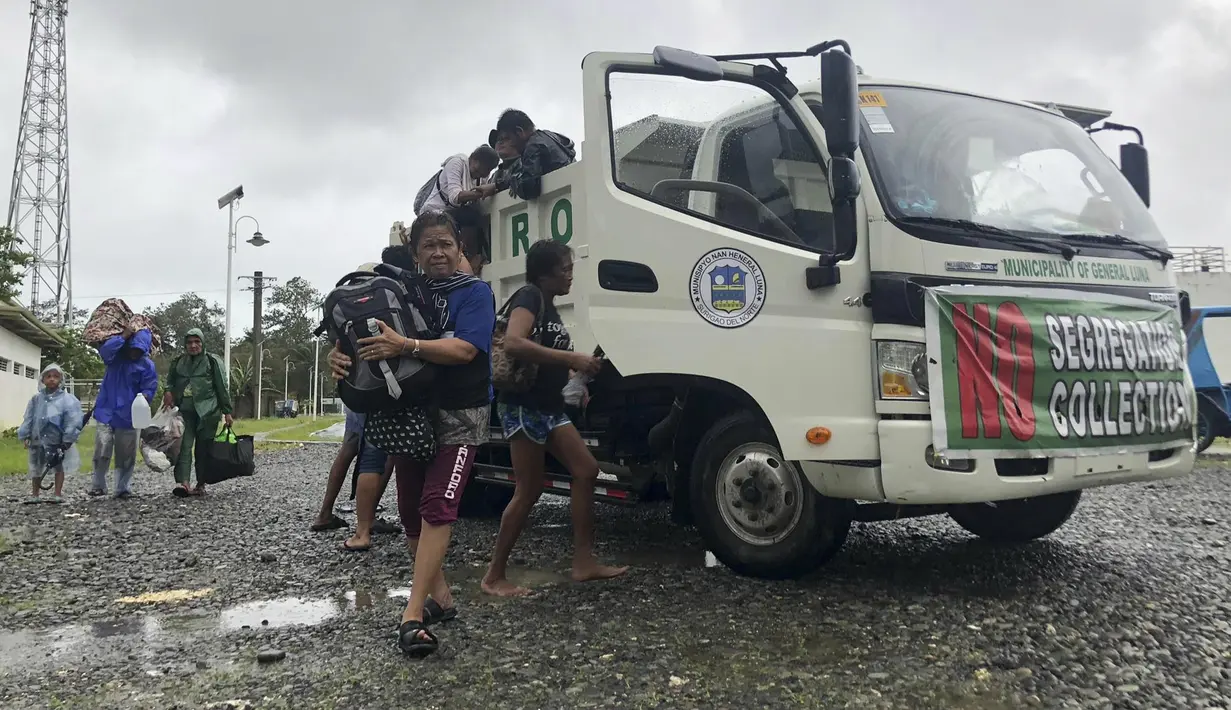 Pengungsi tiba di Kompleks Olahraga Siargao di kota Dapa, pulau Siargao, provinsi Surigao del Norte, Filipina selatan, Kamis (16/12/2021). Puluhan ribu orang sedang dievakuasi ke tempat yang aman ketika Topan Rai mendekati pada Kamis (16/12). (AP Photo)