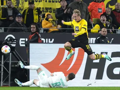 Gelandang Borussia Dortmund Julian Brandt berebut bola dengan bek Werder Bremen Mitchell Weiser dalam laga Bundesliga 2023/2024 pekan 8 yang digelar di Signal Iduna Park, Sabtu (21/10/2023) dini hari WIB. (AP Photo/Martin Meissner)