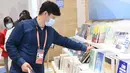 Seorang reporter memilih buku di media center Pameran Impor Internasional China (China International Import Expo/CIIE) ketiga di Shanghai, China timur, pada 3 November 2020. (Xinhua/Zhao Dingzhe)