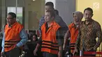 Tersangka anggota DPRD Malang Wiwik Hendri Astuti, M Zainudin dan Suprapto mengenakan rompi tahanan usai menjalani pemeriksaan di Gedung KPK, Jakarta, Rabu (28/3). 5 anggota DPRD Malang resmi ditahan atas dugaan suap APBD-P. (Liputan6.com/Herman Zakharia)
