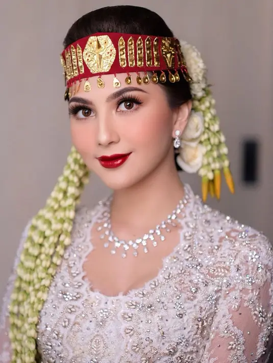 Makeup flawless Jessica Mila di acara pernikahan adat Bataknya. Pesonanya dibalut kebaya putih, dengan aksesori khas Batak, disempurnakan dengan makeup flawless dan pulasan lipstik merah yang glossy. [Foto: Instagram/marlenehariman]