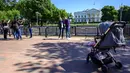 Turis dan warga mengunjungi Lafayette Square dekat Gedung Putih di Washington, DC, pada Selasa (10/5/2021). Lafayette Square dibuka kembali untuk pejalan kaki hampir setahun setelah daerah itu dipagari ketika demonstrasi semakin besar sebagai tanggapan atas kematian George Floyd. (Eric BARADAT/AFP)