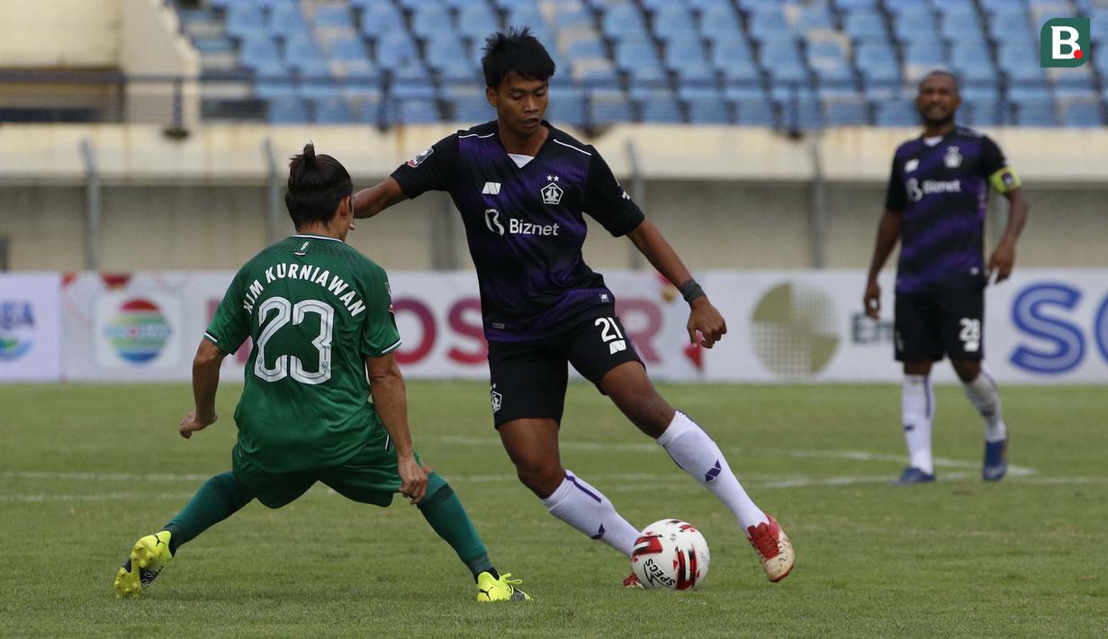 Gelandang Persik Kediri, Mohammad Jordan Zamorano (tengah) dijaga ketat gelandang PS Sleman, Kim Jefferey Kurniawan (kiri) dalam laga matchday ke-3 Grup C Piala Menpora 2021 di Stadion Si Jalak Harupat, Bandung, Kamis (1/4/2021). Persik Kediri kalah 0-1 dari PS Sleman. (Bola.com/Ikhwan Yanuar)