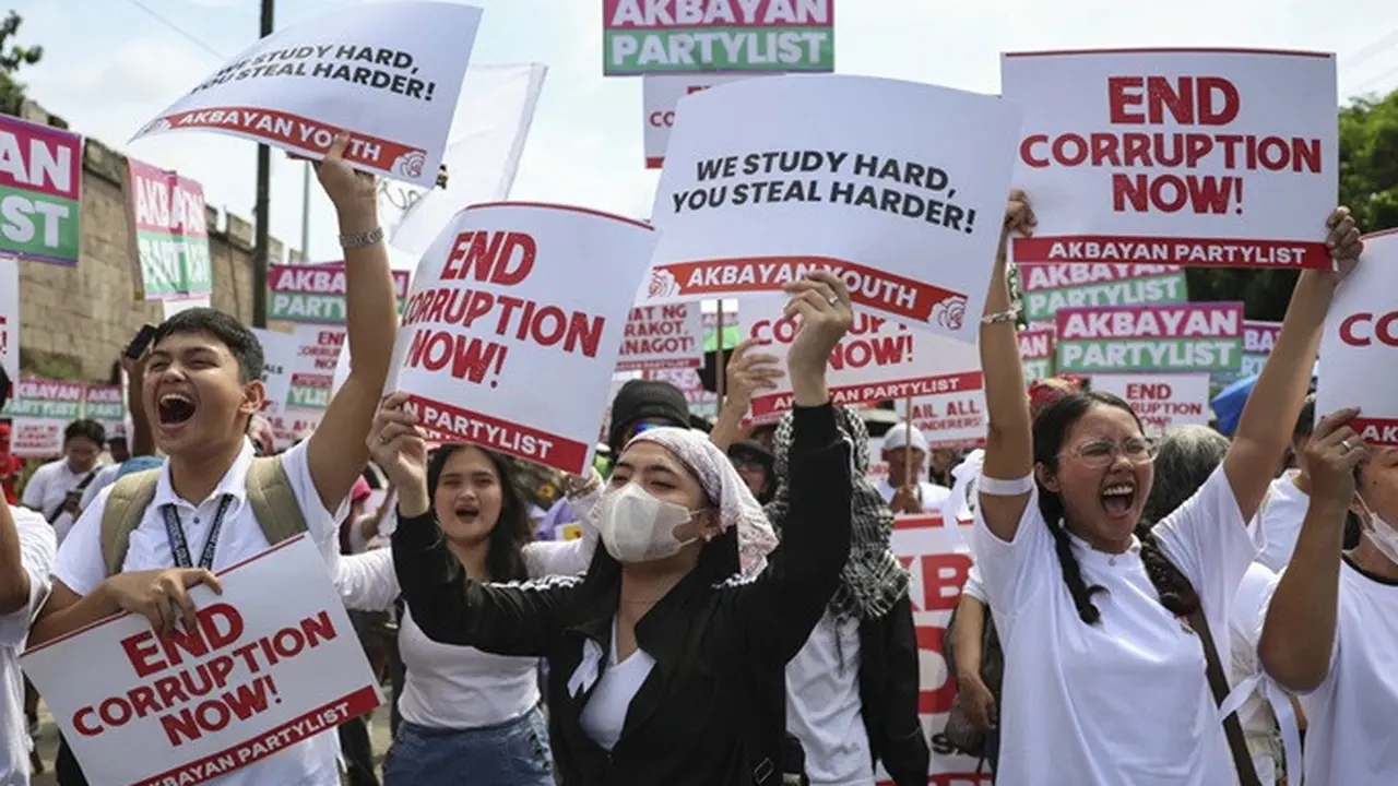 Para pengunjuk rasa membawa poster saat berkumpul dalam aksi menentang korupsi pemerintah di EDSA People Power Monument, Mandaluyong, pinggiran timur Manila, Filipina, Minggu (21/9/2025).
