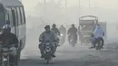 Pengendara melintas di sepanjang jalan di tengah kondisi kabut asap di Lahore, Pakistan (23/11/2021). Kondisi kabut asap yang memburuk membuat Lembaga pendidikan, kantor swasta tutup selama tiga hari seminggu di Lahore. (AFP/Arif Ali)