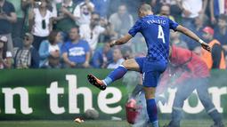 Gelandang Kroasia, Ivan Perisic, menendang suar yang dilempar suporter ke lapangan saat melawan Republik Ceska pada laga Grup D Piala Eropa 2016 di Stadion Geoffrey Guichard, Prancis, Jumat (17/6/2016). (AFP/Jeff Pachoud)
