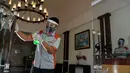 Seorang pekerja dengan mengenakan alat pelindung membersihkan pintu sebuah hotel yang dibuka kembali setelah penutupan selama ditutup selama tiga bulan akibat pandemi COVID-19 di Banda Aceh pada Rabu (15/7/2020). (Photo by CHAIDEER MAHYUDDIN / AFP)