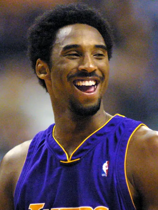 Pemain Los Angeles Lakers Kobe Bryant tertawa dengan rekan satu timnya saat istirahat melawan Phoenix Suns pada kuarter kedua di Phoenix, AZ pada 28 Desember 2000. Bryant telah terpilih menjadi All-Star sebanyak 18 kali. (AFP/Mike Fiala)