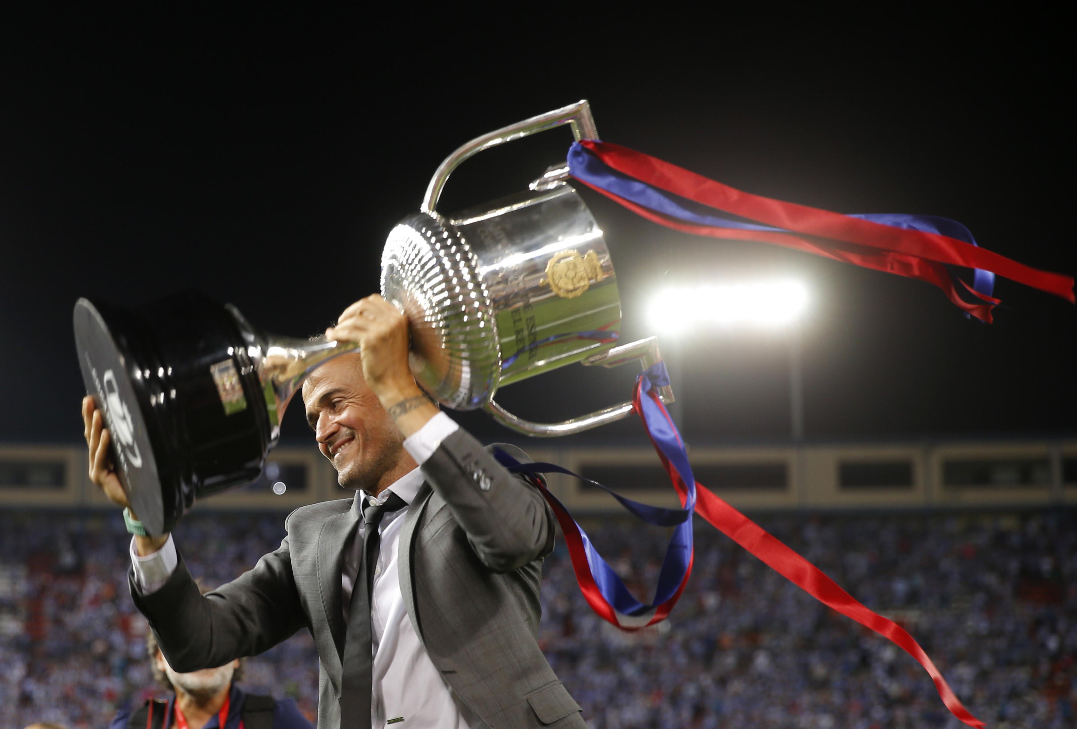 Pelatih FC Barcelona, Luis Enrique, membawa tropi Piala Raja Spanyol (Copa del Rey) di stadion Vicente Calderon, Spanyol, Minggu (28/5). Final Copa del Rey 2016-2017 menjadi laga terakhirnya bersama Messi dkk. (AP Photo)